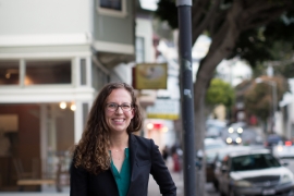 woman stands on street near sign